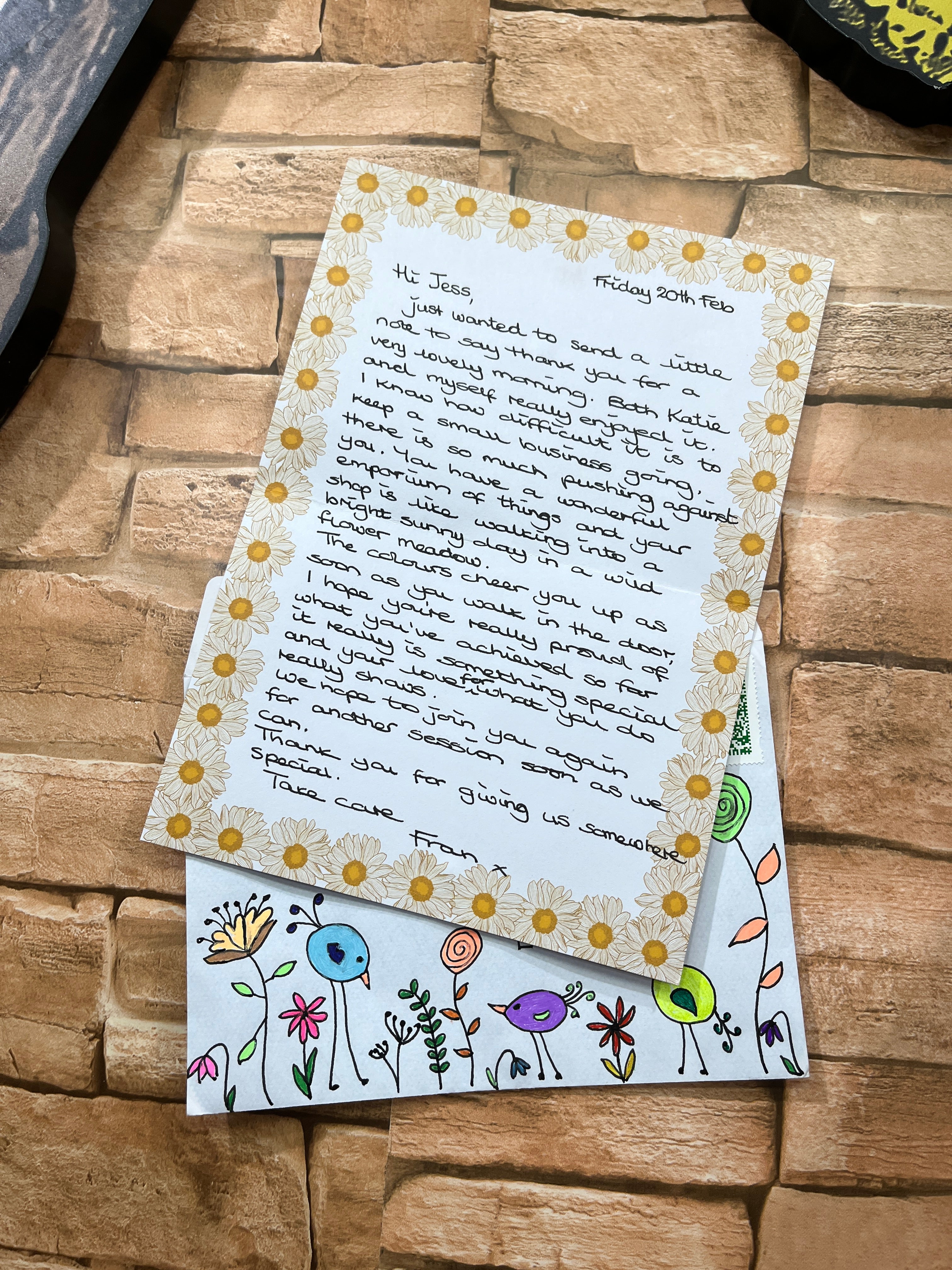 Letter with decorative envelope on a stone surface, 5 star review of the wild fig and fern