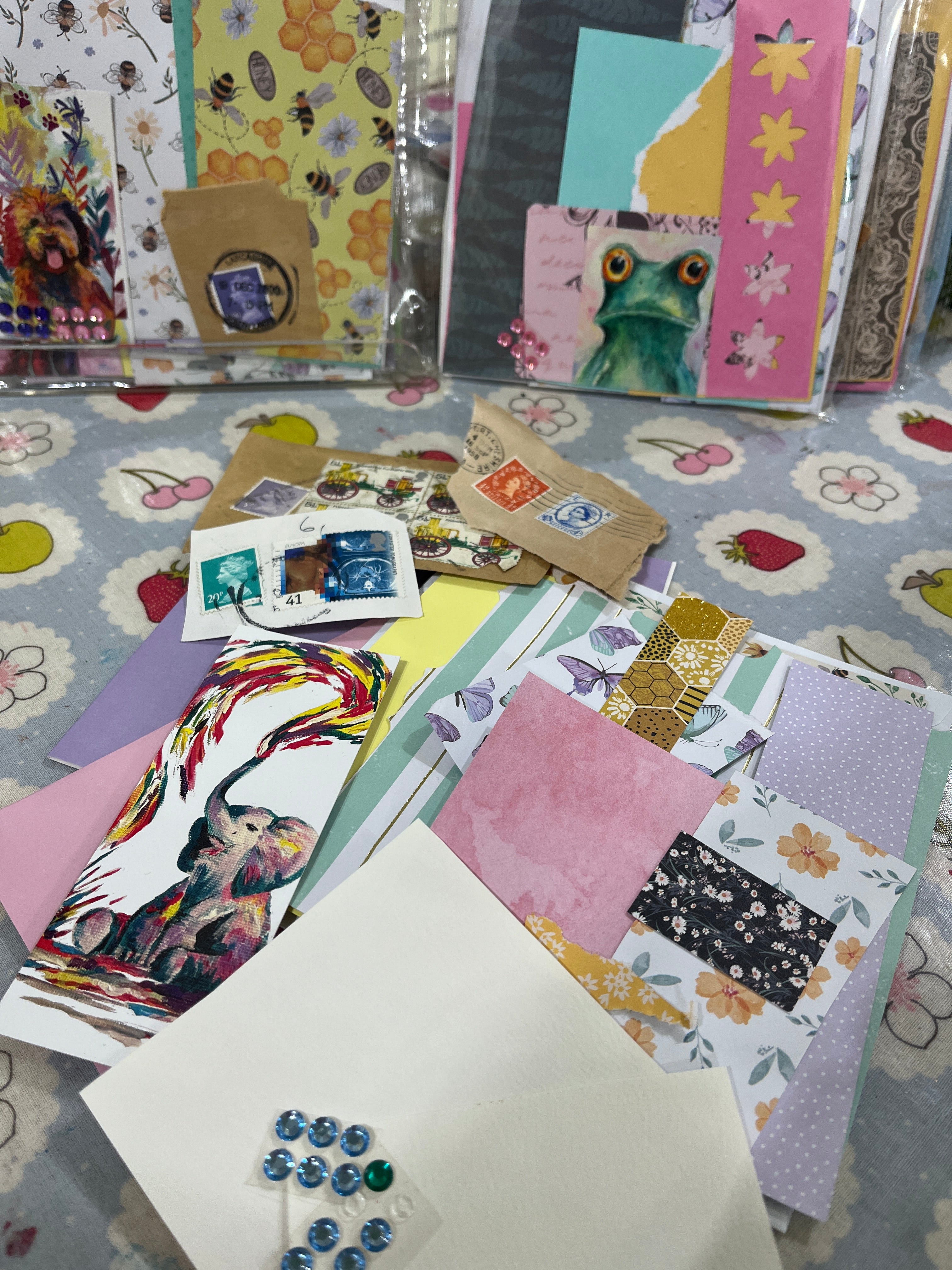card making craft set, scrap card stickers & stamps layed out on a table with colourful animal pictures in the background jj barrs art, the wild fig and fern