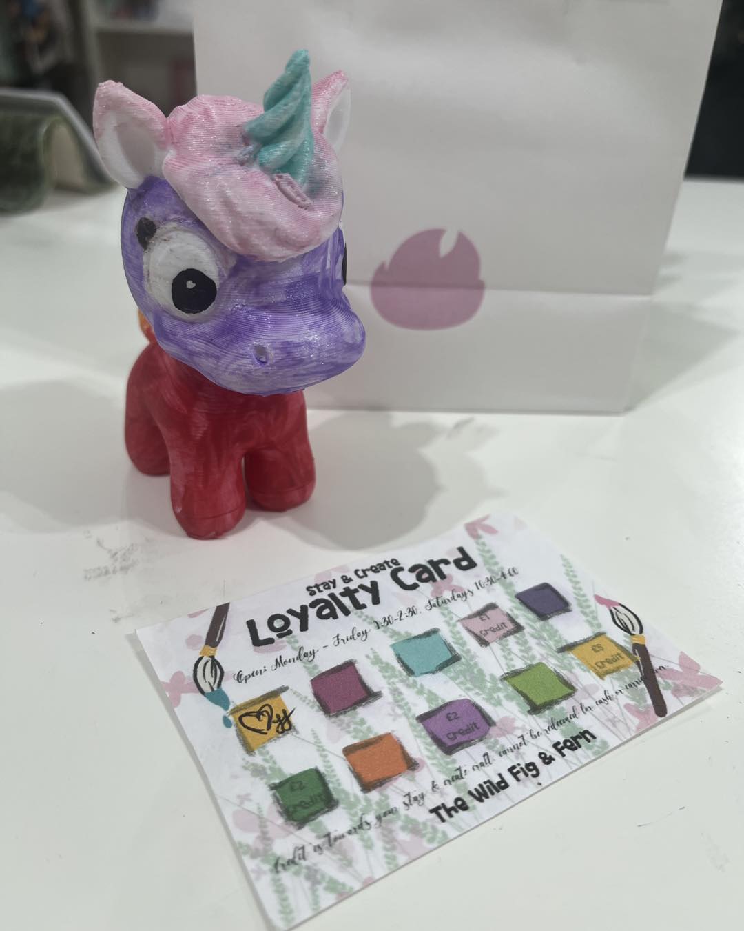 hand painted Unicorn-shaped toy with a 'Loyalty Card' on a white surface