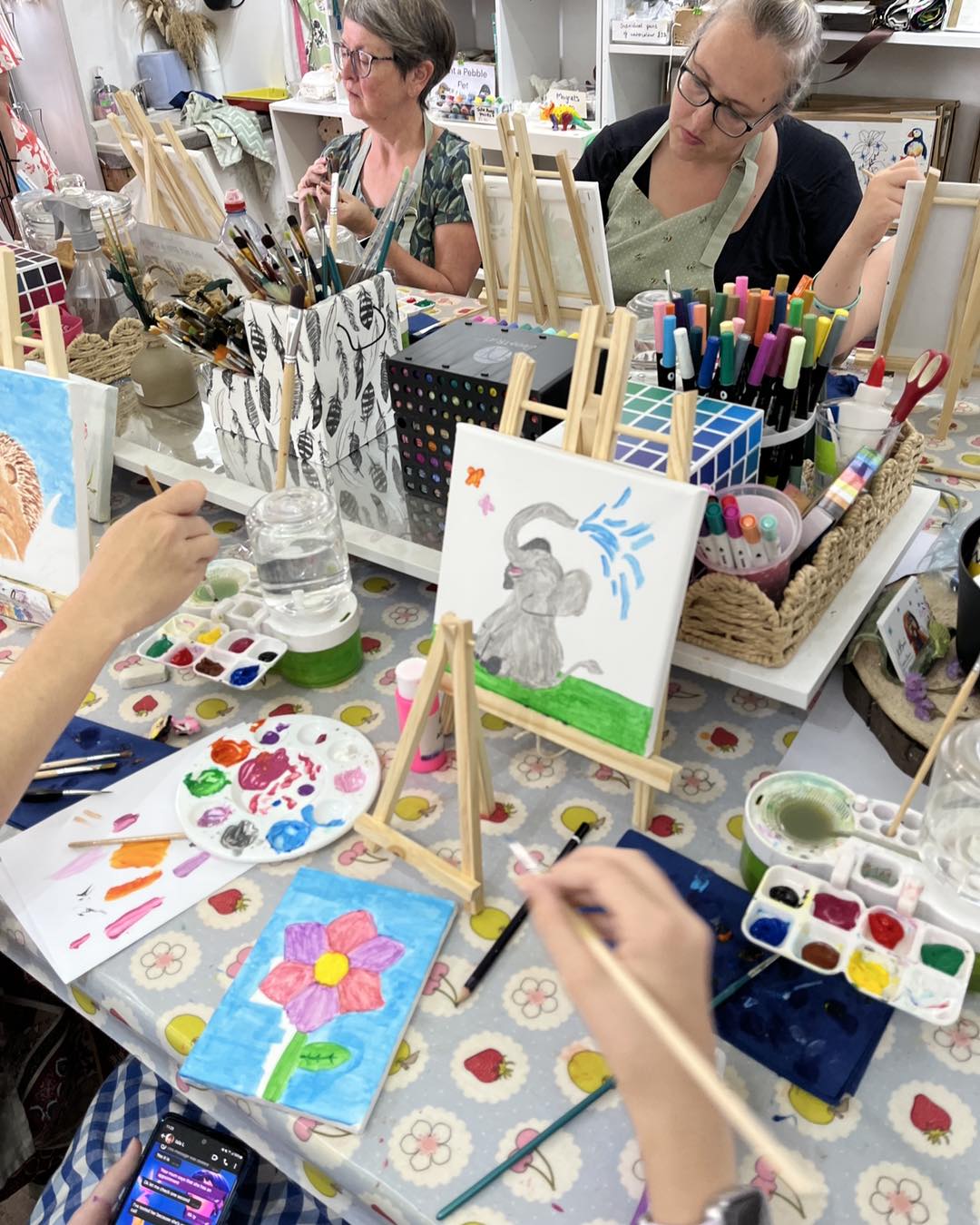 Art class with participants painting at a table at the wild fig and fern