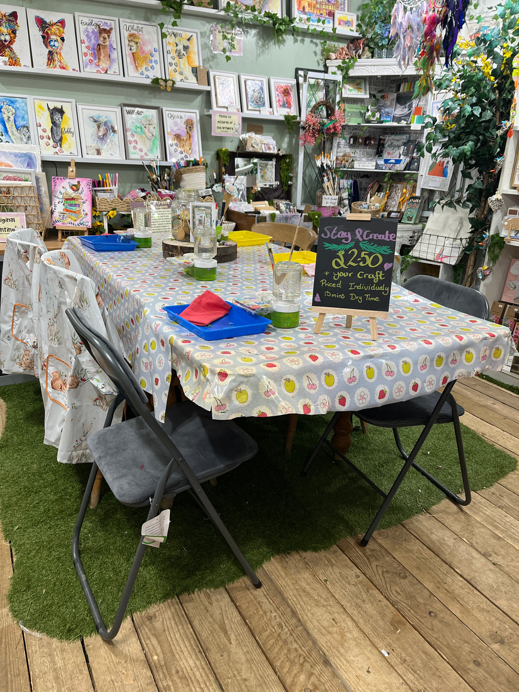 Table with a polka dot tablecloth surrounded by chairs on a wooden deck